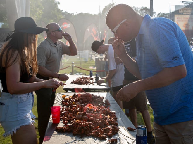 Brian Butrum, right, enjoys a crawfish boil at The Usual Saucespects booth during the Memphis in May World Championship Cooking Contest on Wednesday, May 11, 2022, at the Fairgrounds in Liberty Park. The festival runs through May 14.