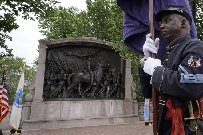 Civil War reenactor Larry Harris, of Philadelphia, marches past the Robert Gould Shaw and the 54th Massachusetts Regiment Memorial that commemorates the famed Civil War unit made up of Black soldiers, during rededication ceremonies of the memorial on the Boston Common on Wednesday. The celebration comes on the 125th anniversary of the original unveiling of the bronze relief, which is considered the nation’s first honoring Black soldiers.