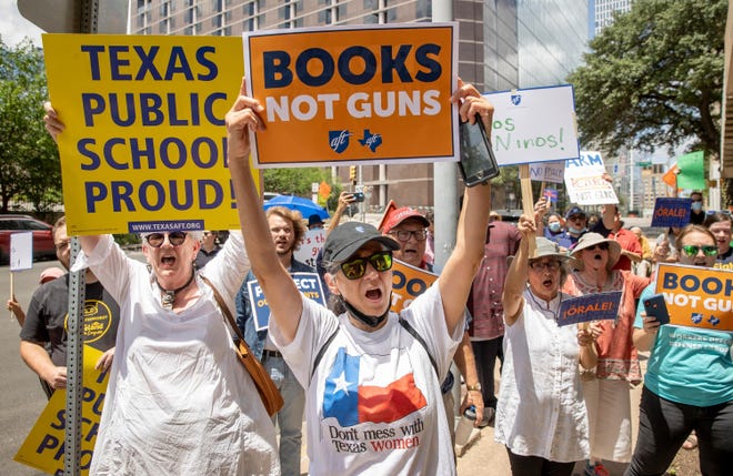 Janet Dudding, left, and Lulu Flores protest outside the office of U.S. Sen. Ted Cruz on Tuesday in downtown Austin, Texas.